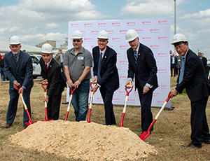 Leaders from Veolia join Arkansas Governor Asa Hutchinson are seen holding shovels at a groundbreaking ceremony for Veolia's Gum Springs facility 